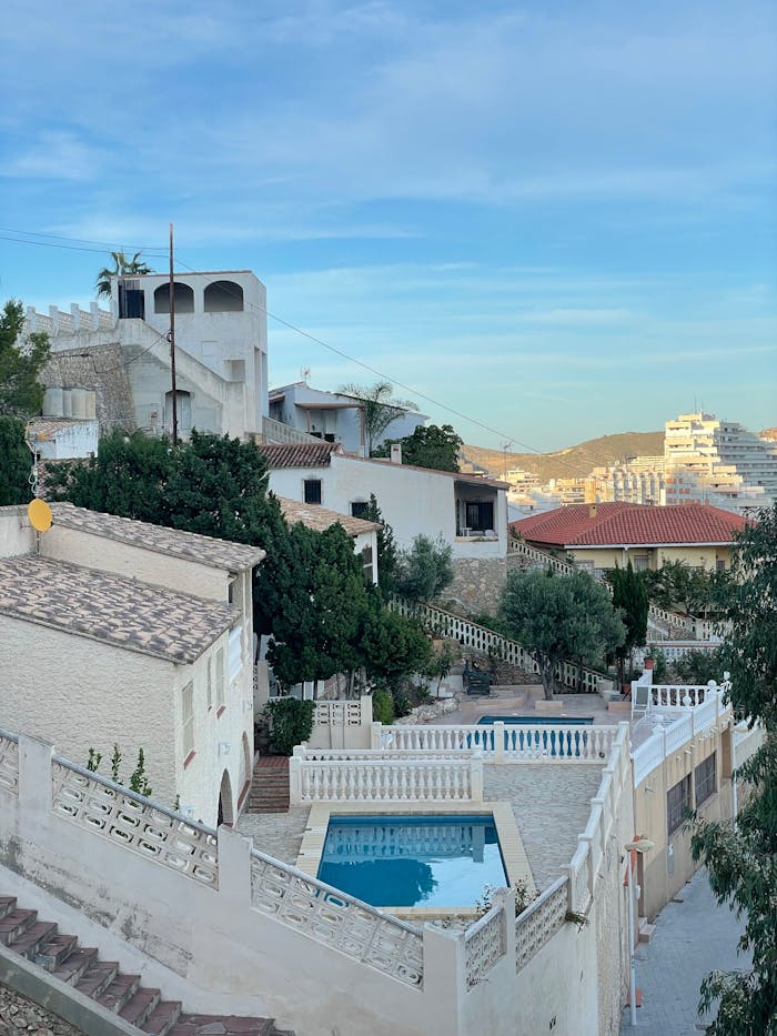 Mediterranean-style villas with pool and scenic landscape at dusk.